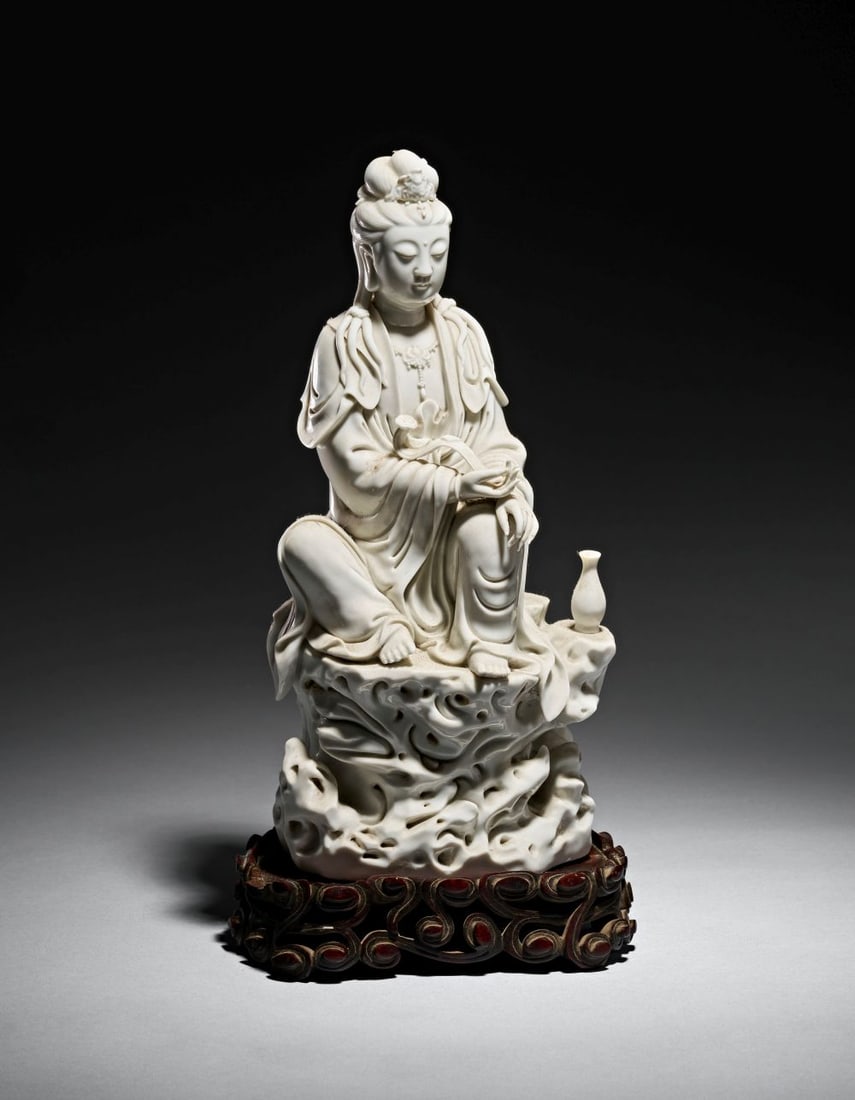 A DEHUA FIGURE OF SEATED GUANYIN EARLY 17TH CENTURY, HE CHAOZONG IMPRESSED SEAL MARK: A DEHUA FIGURE OF SEATED GUANYIN EARLY 17TH CENTURY, HE CHAOZONG IMPRESSED SEAL MARK Modelled in luminous blanc-de-Chine porcelain, this serene figure of Guanyin is seated in contemplative ease upon