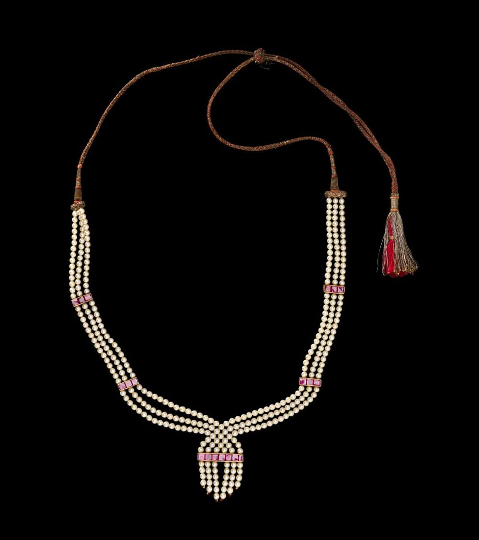 AN INDIAN PEARL & RUBY THREE STRAND NECKLACE, 19TH CENTURY: AN INDIAN PEARL & RUBY THREE STRAND NECKLACE, 19TH CENTURY Composed of three graduated strands of luminous pearls, this necklace embodies the refined opulence of 19th-century Indian courtly ador