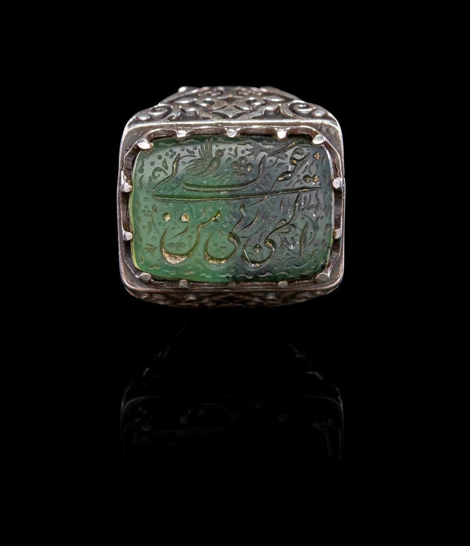 A CALLIGRAPHIC INSCRIBED EMERALD RING DEPICTING BIRDS, 18TH CENTURY, PERSIA: A CALLIGRAPHIC INSCRIBED EMERALD RING DEPICTING BIRDS, 18TH CENTURY, PERSIA This striking emerald ring is set with a rectangular stone of rich, translucent green tone, finely engraved in intaglio wi