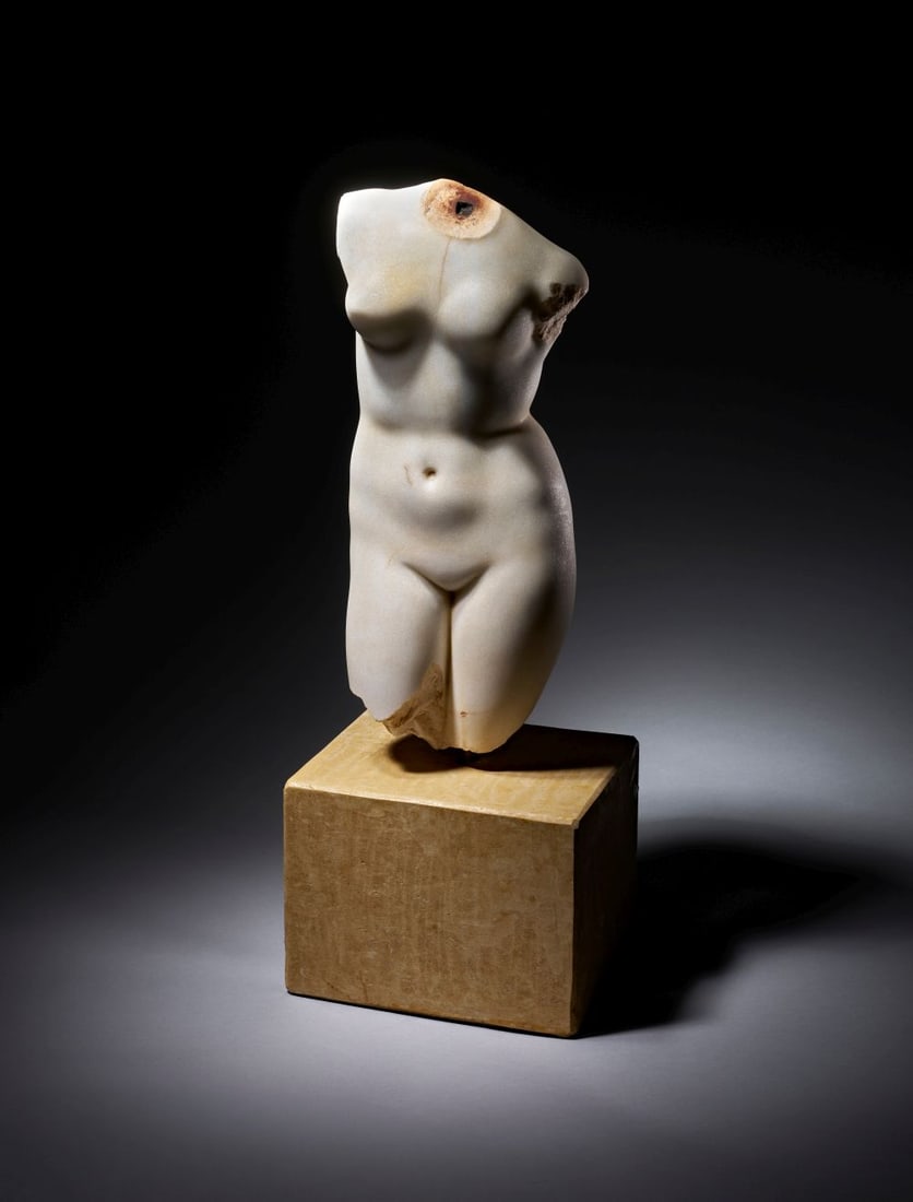 A ROMAN MARBLE TORSO OF VENUS CIRCA 1ST CENTURY B.C.-1ST CENTURY A.D.: A ROMAN MARBLE TORSO OF VENUS CIRCA 1ST CENTURY B.C.-1ST CENTURY A.D. Carved in marble, this Roman torso of Venus preserves the figure from the upper body to the thighs, with the head, arms and lower 