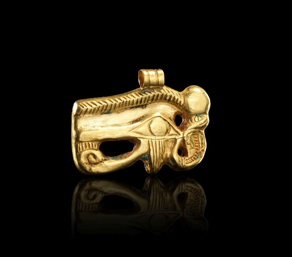 AN EGYPTIAN GOLD WEDJAT EYE AMULET WITH URAEUS, LATE PERIOD-PTOLEMAIC PERIOD CIRCA 664-30 B.C. (1 of 2)