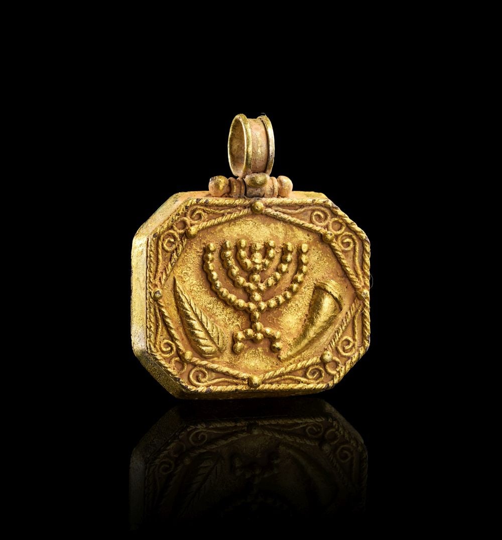 AN ANCIENT JEWISH DEVOTIONAL MENORAH PENDANT, BYZANTINE PERIOD, 4TH-7TH CENTURY A.D. (1 of 2)
