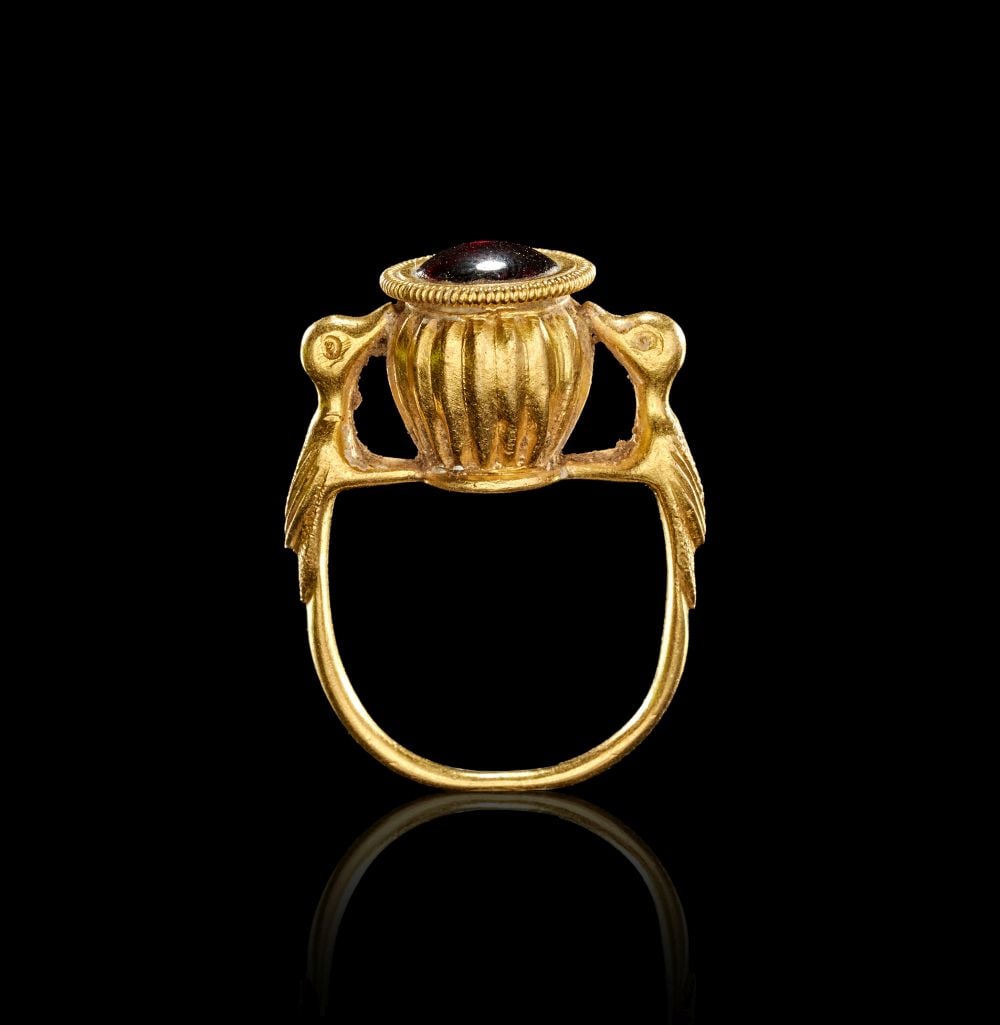 A LATE ROMAN EARLY BYZANTINE GOLD & GARNET RING WITH BIRDS, CIRCA 4TH-6TH CENTURY A.D.: A LATE ROMAN EARLY BYZANTINE GOLD & GARNET RING WITH BIRDS, CIRCA 4TH-6TH CENTURY A.D. Gold ring with a raised bezel in the form of a vase, flanked by birds (woodpecker) and containing a glass set
