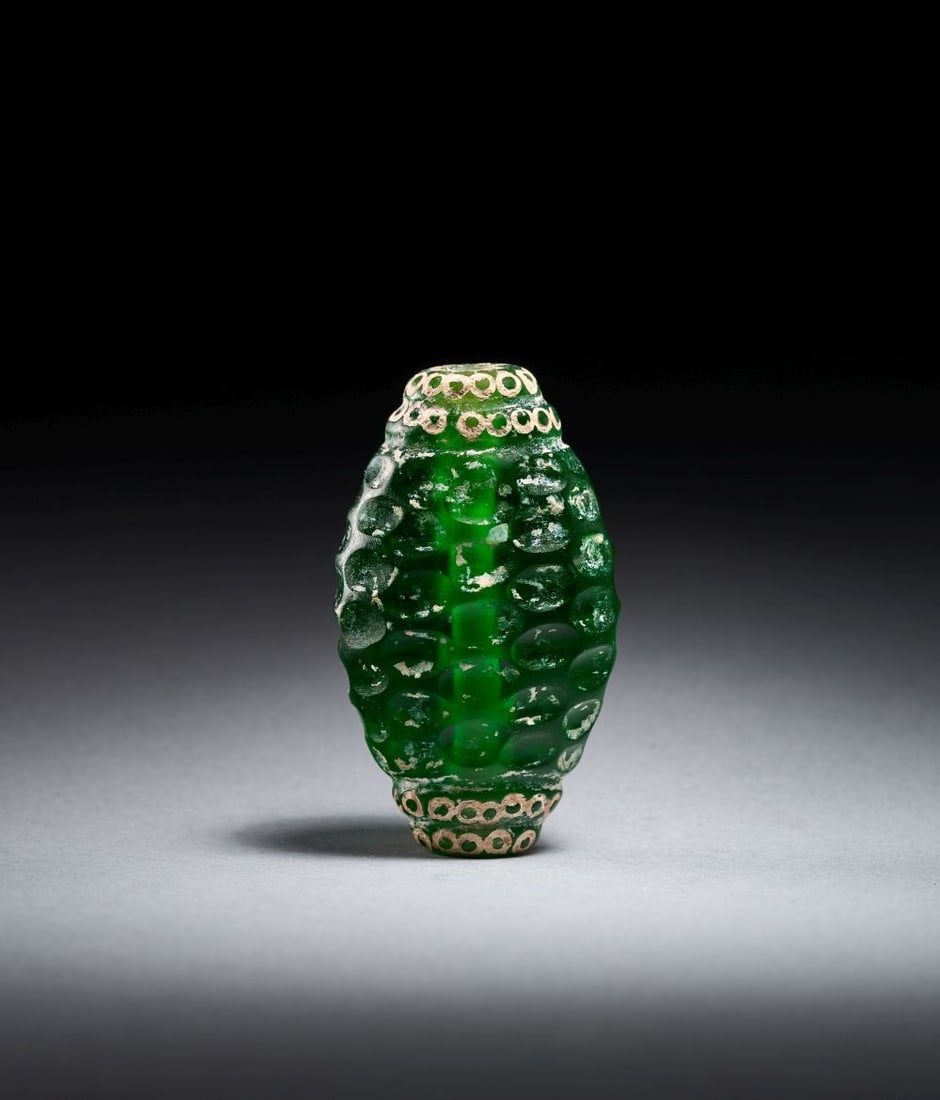 A LARGE EMERALD GREEN SASSANIAN WHEEL CUT GREEN GLASS IN THE FORM OF A DIAMOND PENDANT, IRAN, 6TH-8T: A LARGE EMERALD GREEN SASSANIAN WHEEL CUT GREEN GLASS IN THE FORM OF A DIAMOND PENDANT, IRAN, 6TH-8TH CENTURY A large emerald green Sassanian wheel-cut glass pendant, Iran, 6th–8th century, of e
