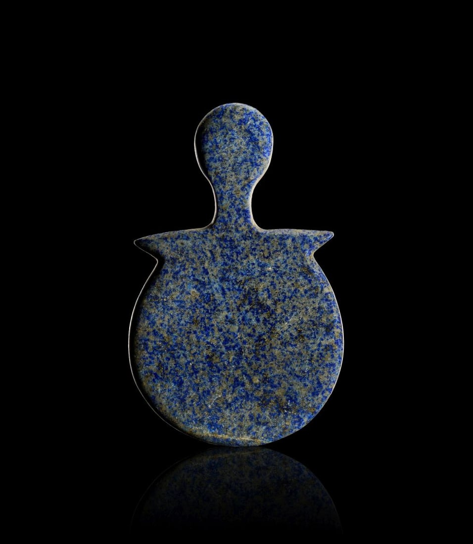 A LAPIS LAZULI IDOL, POSSIBLY ANATOLIA CIRCA 2700-2100 B.C. OR LATER: A LAPIS LAZULI IDOL, POSSIBLY ANATOLIA CIRCA 2700-2100 B.C. OR LATER Carved from a vivid blue lapis lazuli with mottled gold and white veining, this stylised figure is shaped with a rounded head set o