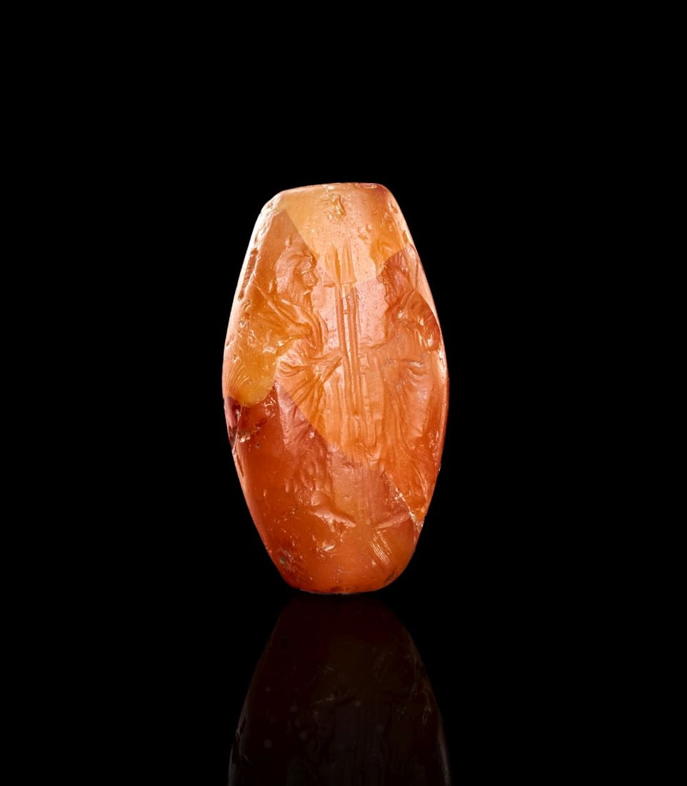 A RARE EASTERN GREEK CARNELIAN SEAL INTAGLIO, EMBLEM WITH ZEUS LABRAUNDOS FOR THE SATRAPY OF CARIA: A RARE EASTERN GREEK CARNELIAN SEAL INTAGLIO, EMBLEM WITH ZEUS LABRAUNDOS FOR THE SATRAPY OF CARIA 4th century B.C. H: 32 mm This rare representation is composed with two bearded and draped male figur