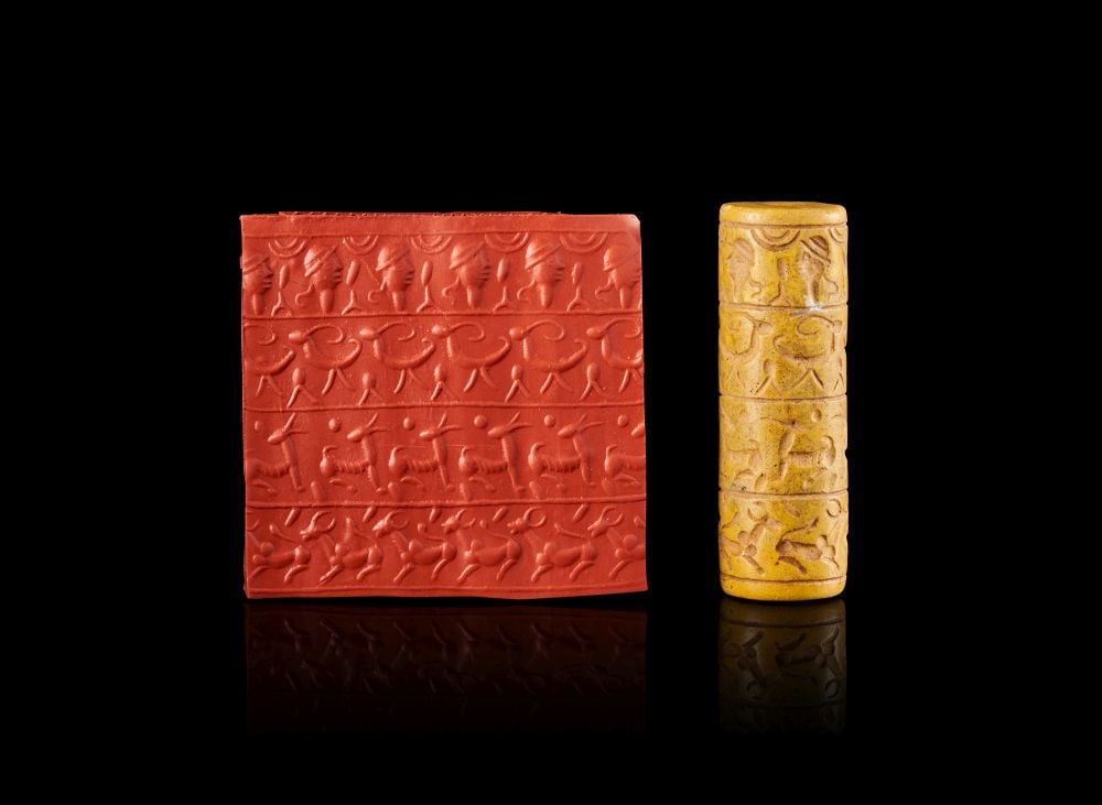 A NEO-BABYLONIAN STONE CYLINDER SEAL CIRCA 900-700 B.C.: A NEO-BABYLONIAN STONE CYLINDER SEAL CIRCA 900-700 B.C. A Neo-Babylonian stone cylinder seal, carved from warm yellow-toned stone and pierced vertically for suspension or stringing. The surface is div