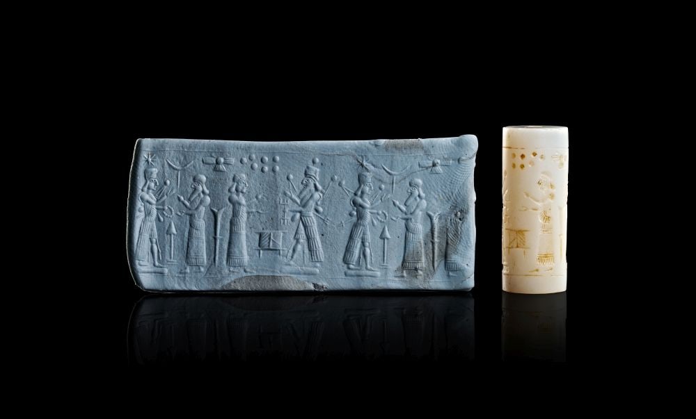 A MIDDLE ASSYRIAN AGATE CYLINDER SEAL CIRCA 13TH CENTURY B.C.: A MIDDLE ASSYRIAN AGATE CYLINDER SEAL CIRCA 13TH CENTURY B.C. A Middle Assyrian agate cylinder seal, carved from pale cream-white stone and pierced vertically for suspension. The cylindrical form is e