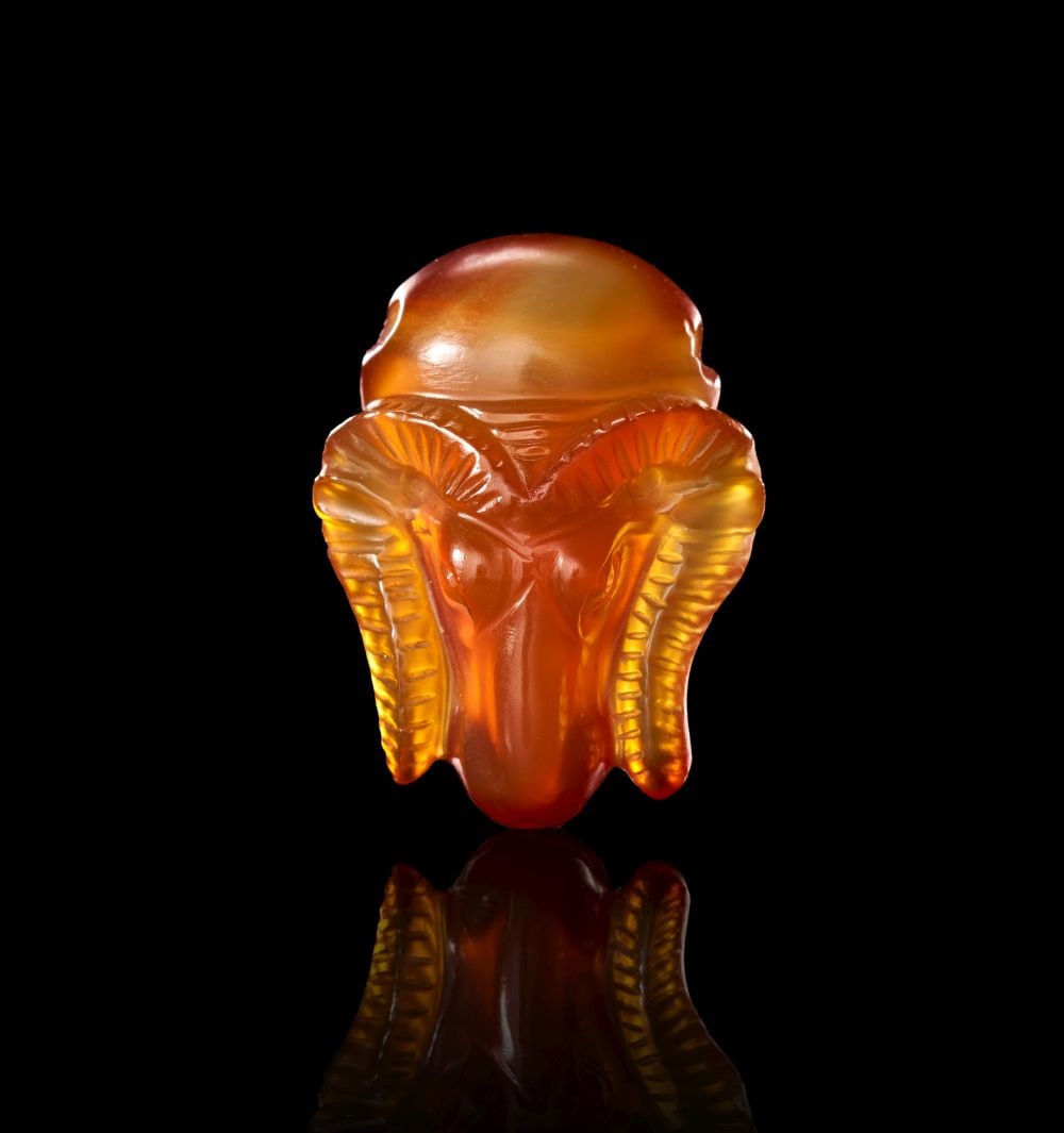 A CARNELIAN AMULET PENDANT IN THE FORM OF A FRONTAL RAM HEAD, SURMOUNTED BY A SOLAR DISC (KHUNM) LAT (1 of 2)