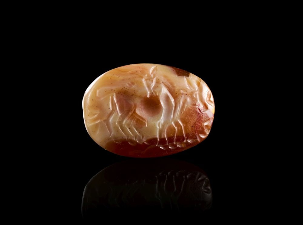 A GREEK BANDED AGATE SCARABOID WITH A BULL & GODDESS, LATE ARCHAIC PERIOD, CIRCA 475 B.C.: A GREEK BANDED AGATE SCARABOID WITH A BULL & GODDESS, LATE ARCHAIC PERIOD, CIRCA 475 B.C. A Greek banded agate scaraboid, carved from a warm, variegated stone with translucent cream, amber, reddis