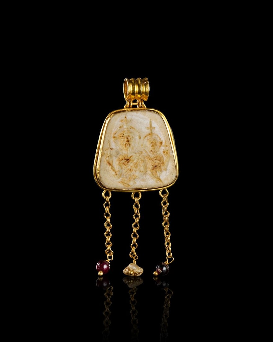 A BYZANTINE GOLD PENDANT DEPICTING A PORTRAIT OF THE EMPEROR HERACLIUS & SON HERACLIUS CONSTANTINE,: A BYZANTINE GOLD PENDANT DEPICTING A PORTRAIT OF THE EMPEROR HERACLIUS & SON HERACLIUS CONSTANTINE, A Byzantine gold pendant set with a pale, softly translucent stone panel, finely engraved with t