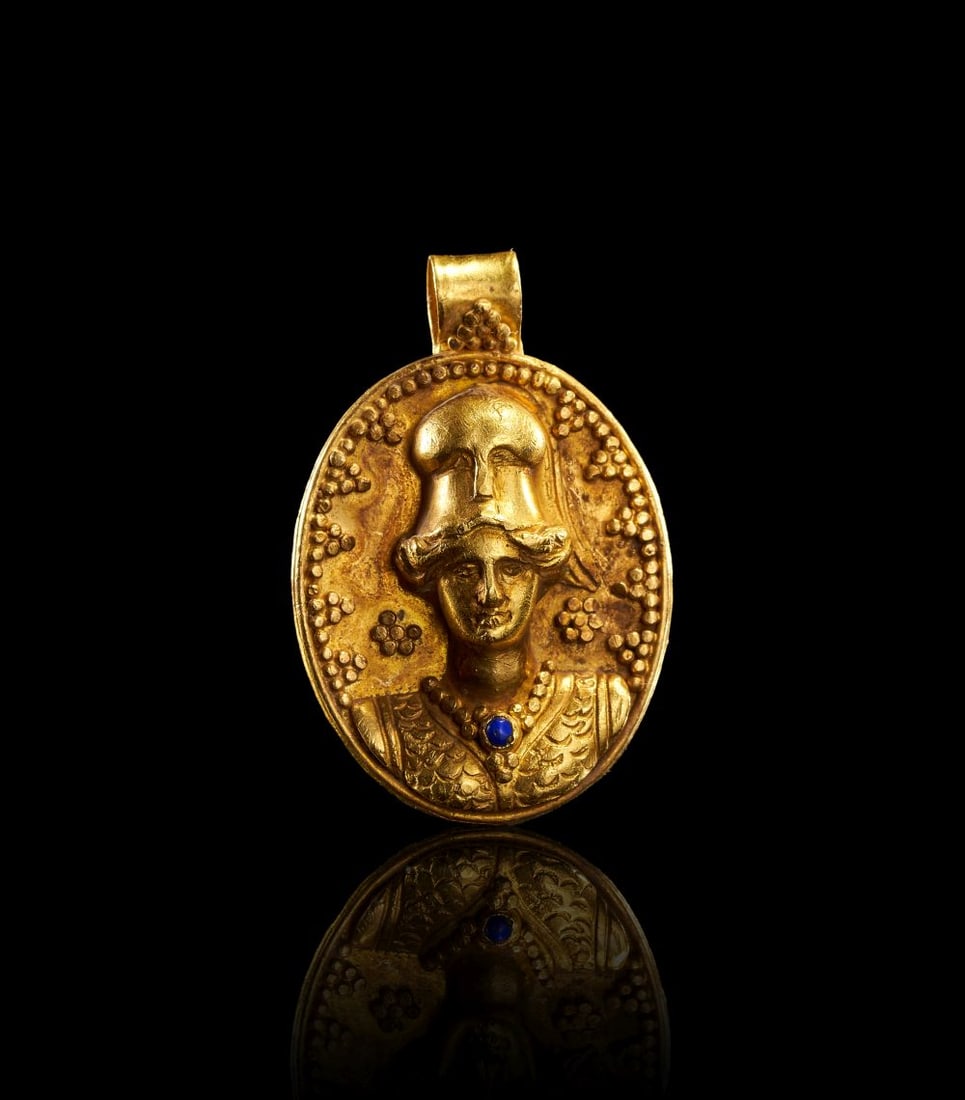A ROMAN GOLD PENDANT WITH MINERVA, CIRCA 1ST-2ND CENTURY A.D.: A ROMAN GOLD PENDANT WITH MINERVA, CIRCA 1ST-2ND CENTURY A.D. A Roman gold pendant of oval form, finely worked in relief with the bust of Minerva wearing a crested helmet. The goddess is shown frontal
