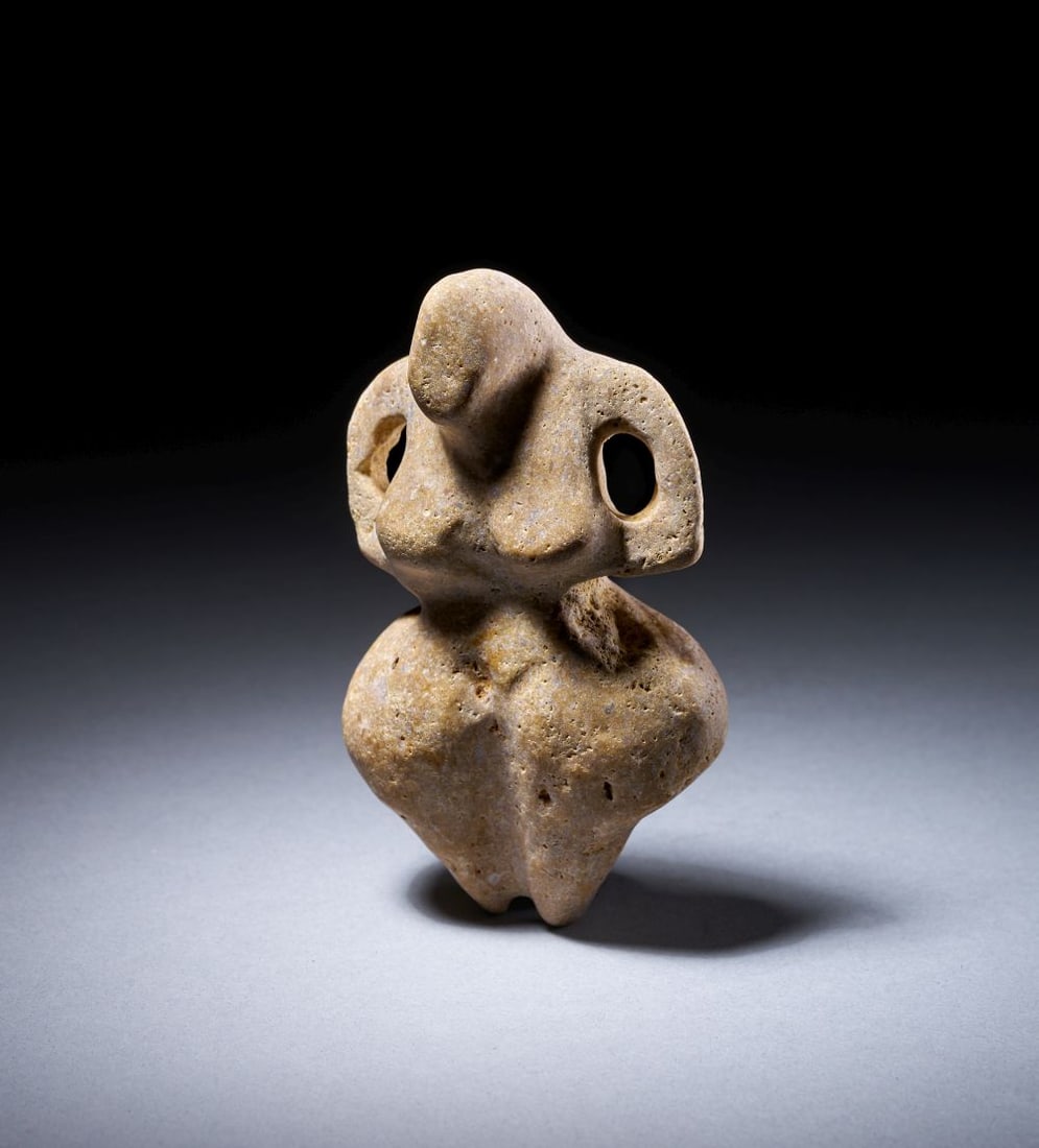 AN ANATOLIAN MARBLE MOTHER GODDESS, NEOLITHIC PERIOD, CIRCA 6TH MILLENNIUM B.C.: AN ANATOLIAN MARBLE MOTHER GODDESS, NEOLITHIC PERIOD, CIRCA 6TH MILLENNIUM B.C. An Anatolian marble mother goddess figure of highly stylised form, carved with a rounded, abstract head rising from broa