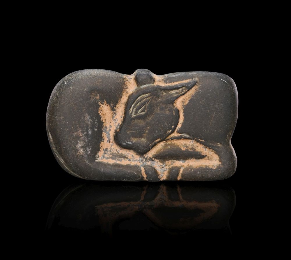 A MESOPOTAMIAN BLACK STONE RECUMBENT BULL JEMDET NASR, CIRCA 3100-2900 B.C.: A MESOPOTAMIAN BLACK STONE RECUMBENT BULL JEMDET NASR, CIRCA 3100-2900 B.C. A Mesopotamian black stone recumbent bull, Jemdet Nasr, circa 3100-2900 B.C. The animal is shown lying with its body compres