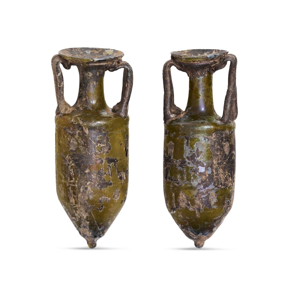 A PAIR OF ROMAN DARK OLIVE GREEN GLASS AMPHORAE, CIRCA 1ST-2ND CENTURY A.D. (1 of 4)