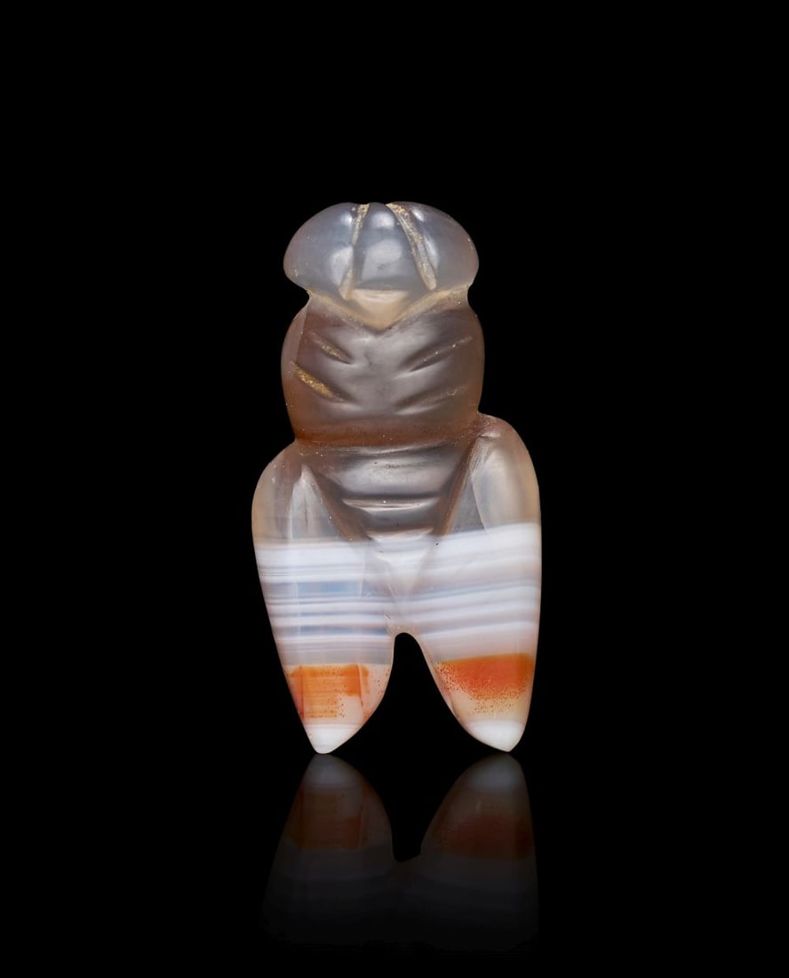 A NEAR EASTERN BANDED AGATE AMULET IN THE FORM OF A BEE, 2ND-1ST MILLENNIUM B.C.: A NEAR EASTERN BANDED AGATE AMULET IN THE FORM OF A BEE, 2ND-1ST MILLENNIUM B.C. Carved from banded agate, this small amulet takes the form of a bee, the natural layers of the stone used to striking v