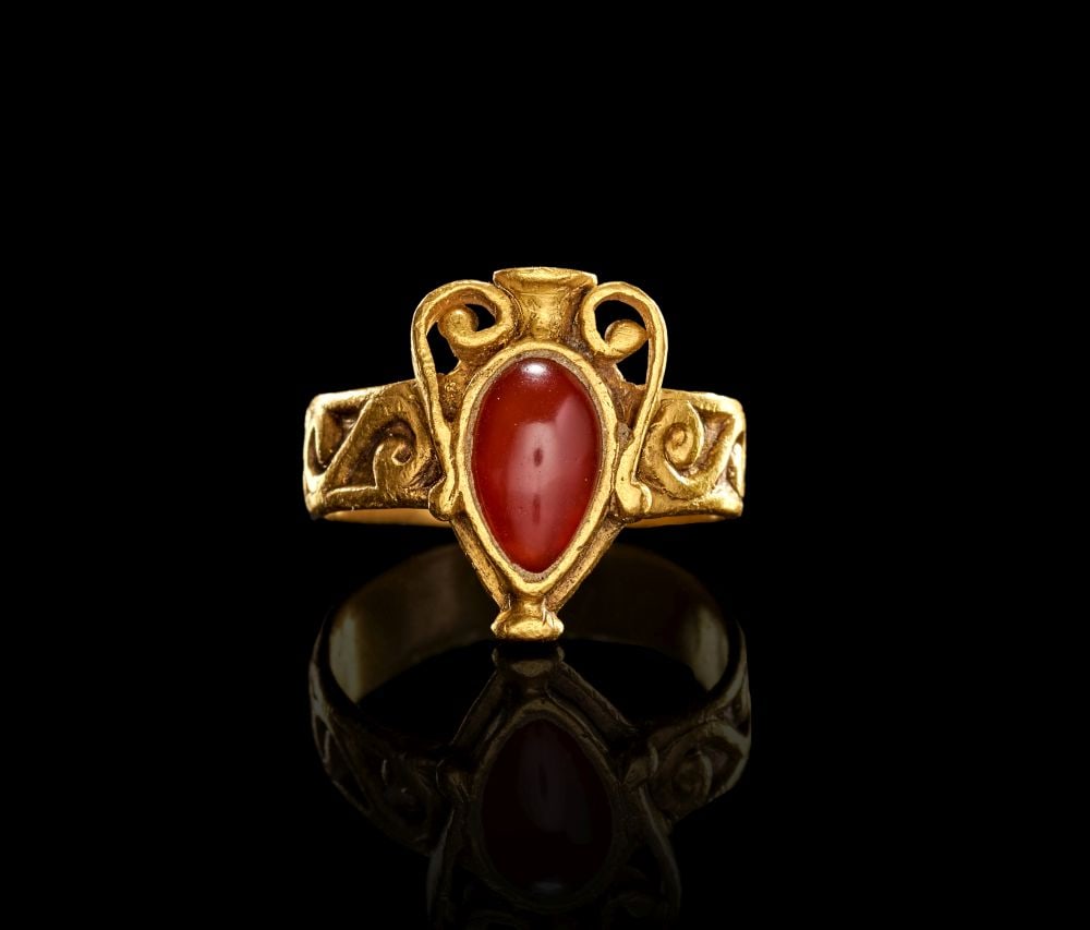 A GREEK GOLD AND GARNET FINGER RING LATE HELLENISTIC PERIOD, CIRCA 2ND-1ST CENTURY B.C.: A GREEK GOLD AND GARNET FINGER RING LATE HELLENISTIC PERIOD, CIRCA 2ND-1ST CENTURY B.C. A Greek gold finger ring set with a garnet, dating to the Late Hellenistic period, circa 2nd–1st century B