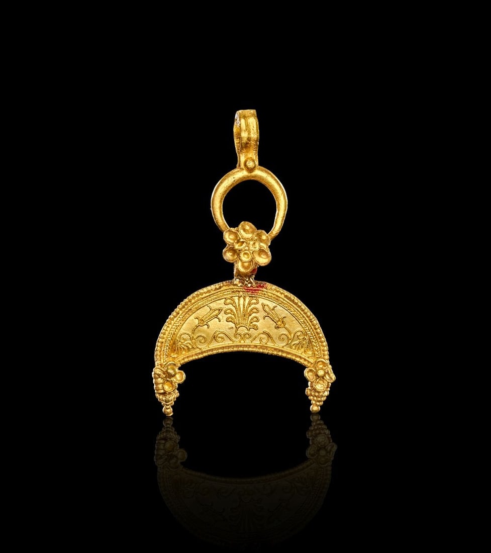 A GREEK GOLD GOLD LUNATE PENDANT HELLENISTIC PERIOD, CIRCA 2ND-1ST CENTURY B.C.: A GREEK GOLD GOLD LUNATE PENDANT HELLENISTIC PERIOD, CIRCA 2ND-1ST CENTURY B.C. Formed in gold, this Hellenistic pendant takes the shape of a lunate crescent with a suspension loop above. The front is