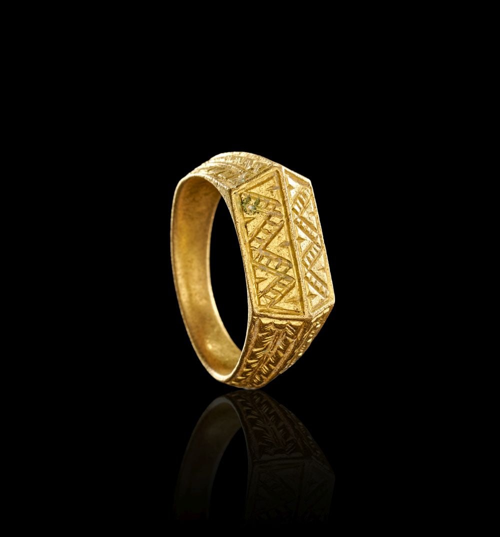 A SELJUK GEOMETRIC GOLD RING PERSIA, LATE 12TH/EARLY 13TH CENTURY: A SELJUK GEOMETRIC GOLD RING PERSIA, LATE 12TH/EARLY 13TH CENTURY Formed in gold, this Seljuk ring has a broad architectural profile, with a flat rectangular bezel and tapering shoulders. The hoop is 