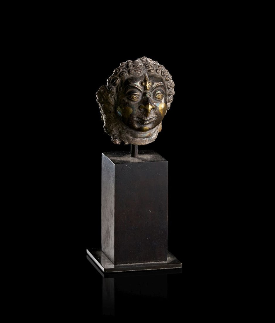 A GILT DECORATED BHAIRAVA MASK SOUTH INDIA, VIJAYANAGARA PERIOD, 15TH CENTURY: A GILT DECORATED BHAIRAVA MASK SOUTH INDIA, VIJAYANAGARA PERIOD, 15TH CENTURY Cast and worked as a small devotional mask, this gilt-decorated representation of Bhairava presents the fierce form of Shi