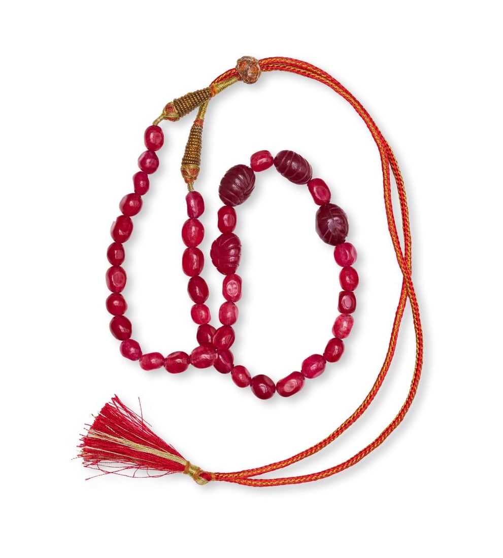 A STRAND OF CARVER RUBY BEADS, MUGHAL, INDIA, 19TH/20TH CENTURY: A STRAND OF CARVER RUBY BEADS, MUGHAL, INDIA, 19TH/20TH CENTURY Comprising a strand of richly coloured ruby beads, this necklace is arranged with a combination of smaller polished beads and larger car