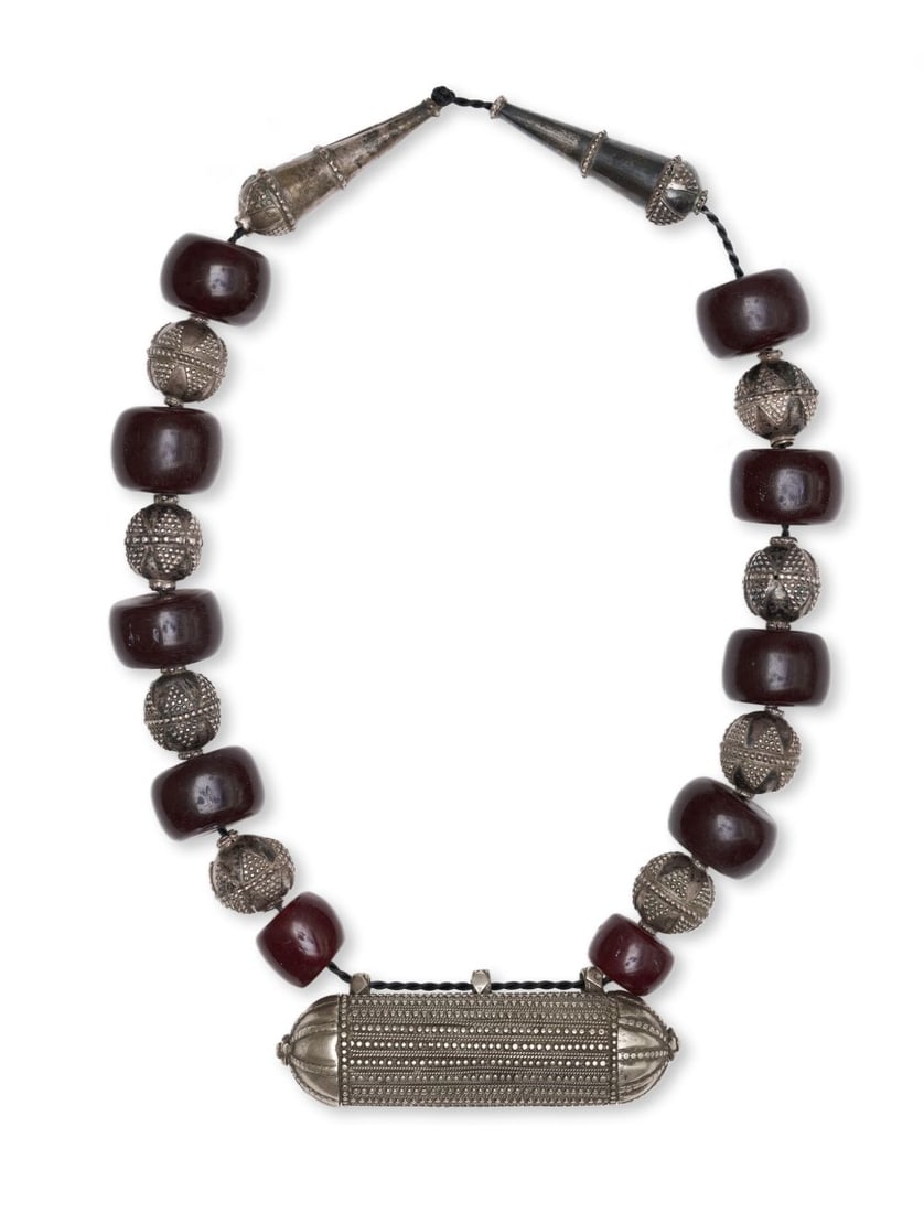A CENTRAL ASIAN OR TRIBAL CHERRY AMBER & SILVER NECKLACE, 20TH CENTURY: A CENTRAL ASIAN OR TRIBAL CHERRY AMBER & SILVER NECKLACE, 20TH CENTURY Comprising a necklace of deep cherry amber beads interspersed with silver spherical ornaments, this piece is centred by a lar