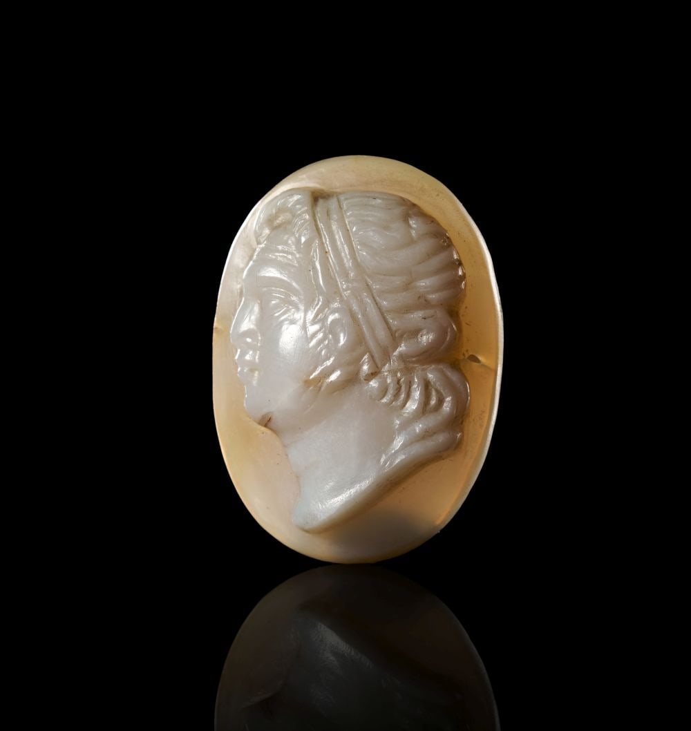 A ROMAN AGATE CAMEO, BUST OF A ROMAN EMPEROR. CIRCA: 1ST-2ND CENTURY A.D.: A ROMAN AGATE CAMEO, BUST OF A ROMAN EMPEROR. CIRCA: 1ST-2ND CENTURY A.D. Carved from layered agate, the oval cameo presents a bust of a Roman emperor in profile, the pale upper stratum reserved for t