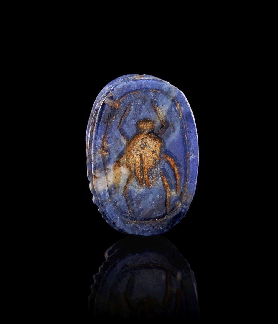 AN PHOENICIAN LAPIS LAZULI SCARAB, WITH AN ENGRAVED SPIDER, 6TH CENTURY B.C.: AN PHOENICIAN LAPIS LAZULI SCARAB, WITH AN ENGRAVED SPIDER, 6TH CENTURY B.C. Carved from lapis lazuli of deep blue tone, this small scarab has a compact, rounded form, its surface enlivened by paler n