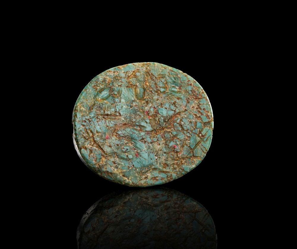 ROMAN-EGYPTIAN MOTTLED GREEN JASPER SEAL WITH MAGICAL CONTEXT, CIRCA: 1ST CENTURY B.C.: ROMAN-EGYPTIAN MOTTLED GREEN JASPER SEAL WITH MAGICAL CONTEXT, CIRCA: 1ST CENTURY B.C. Carved from mottled green jasper, this small oval seal has a rounded, tactile form and a dense, variegated surfac