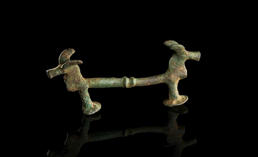 A LURISTAN BRONZE HORSE ATTACHMENT, CIRCA 9TH-7TH CENTURY: A LURISTAN BRONZE HORSE ATTACHMENT, CIRCA 9TH-7TH CENTURY Cast in bronze, this horse attachment is formed as an elongated bar terminating at either end in stylised animal heads. The surface has develo