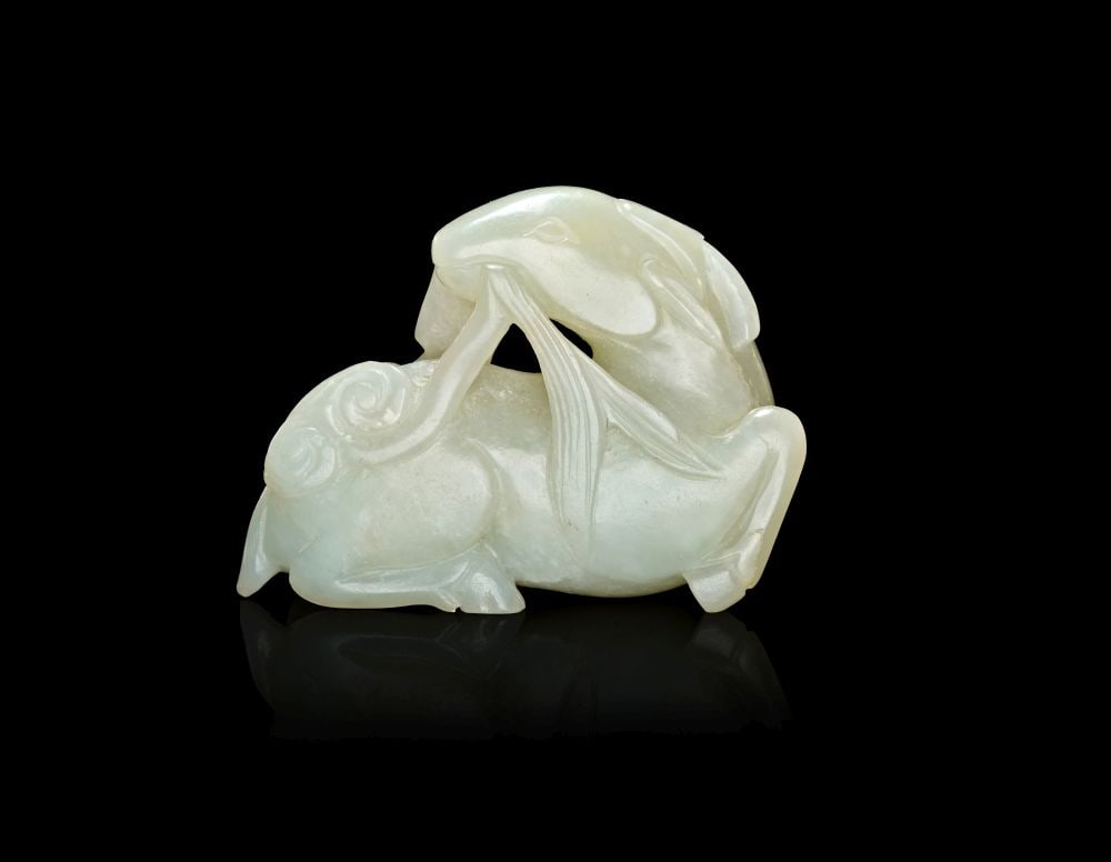 A CHINESE PALE GREEN JADE CARVING OF A RECUMBENT RAM, QING DYNASTY (1644-1911) (1 of 2)