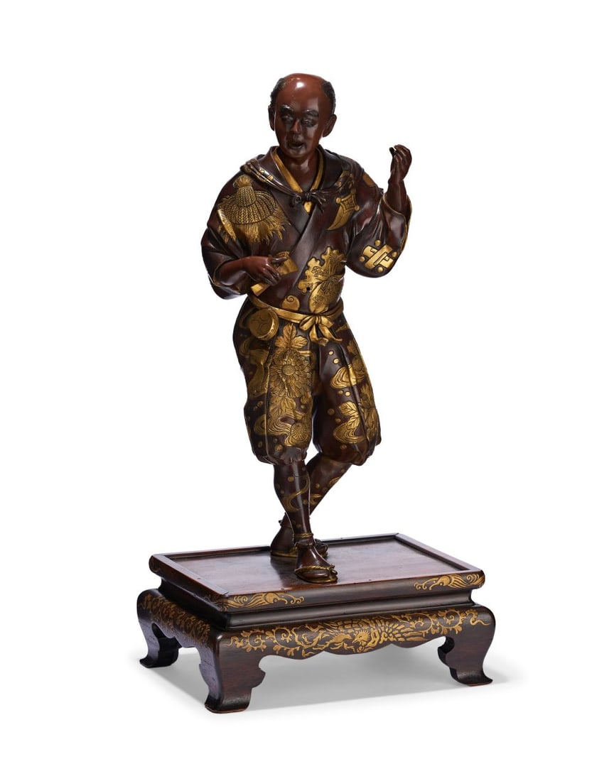 MIYAO EISUKE: A GILT-DECORATED BRONZE FIGURE OF A MAN, 19TH CENTURY: MIYAO EISUKE: A GILT-DECORATED BRONZE FIGURE OF A MAN, 19TH CENTURY The bronze figure is finely modelled as a Japanese man in lively motion, poised on one foot upon a rectangular lacquered wood stand 