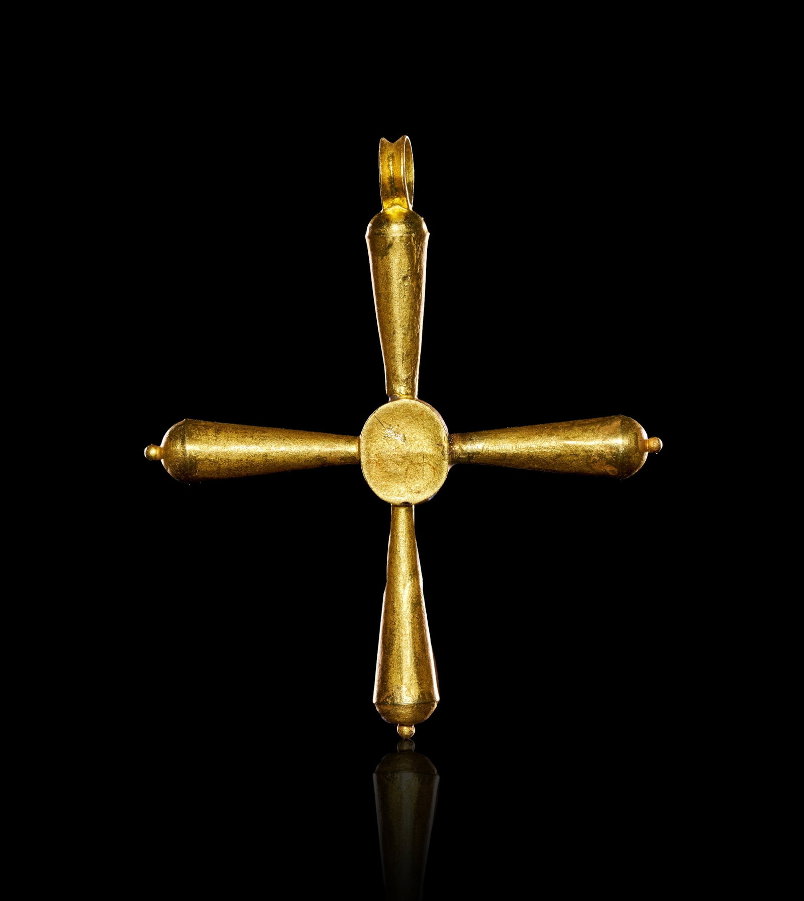 A BYZANTINE GOLD AND EMERALD CROSS PENDANT CIRCA 6TH CENTURY A.D.: A BYZANTINE GOLD AND EMERALD CROSS PENDANT, EASTERN MEDITERRANEAN, CIRCA 6TH CENTURY A.D. Of equal-armed Greek cross form, the four tapering tubular arms rising from a circular central boss and termin