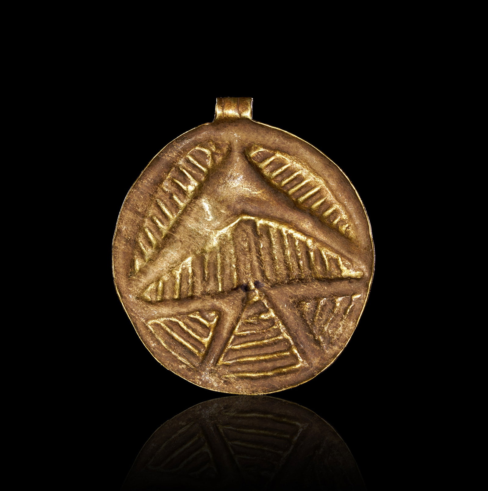 A VIKING GOLD AMULET, CIRCA 10TH CENTURY A.D. OR LATER: A VIKING GOLD AMULET, CIRCA 10TH CENTURY A.D. OR LATEROf circular form, the thin gold disc worked in repoussé from the reverse to produce a stylised bird of prey shown from above with wings outspread