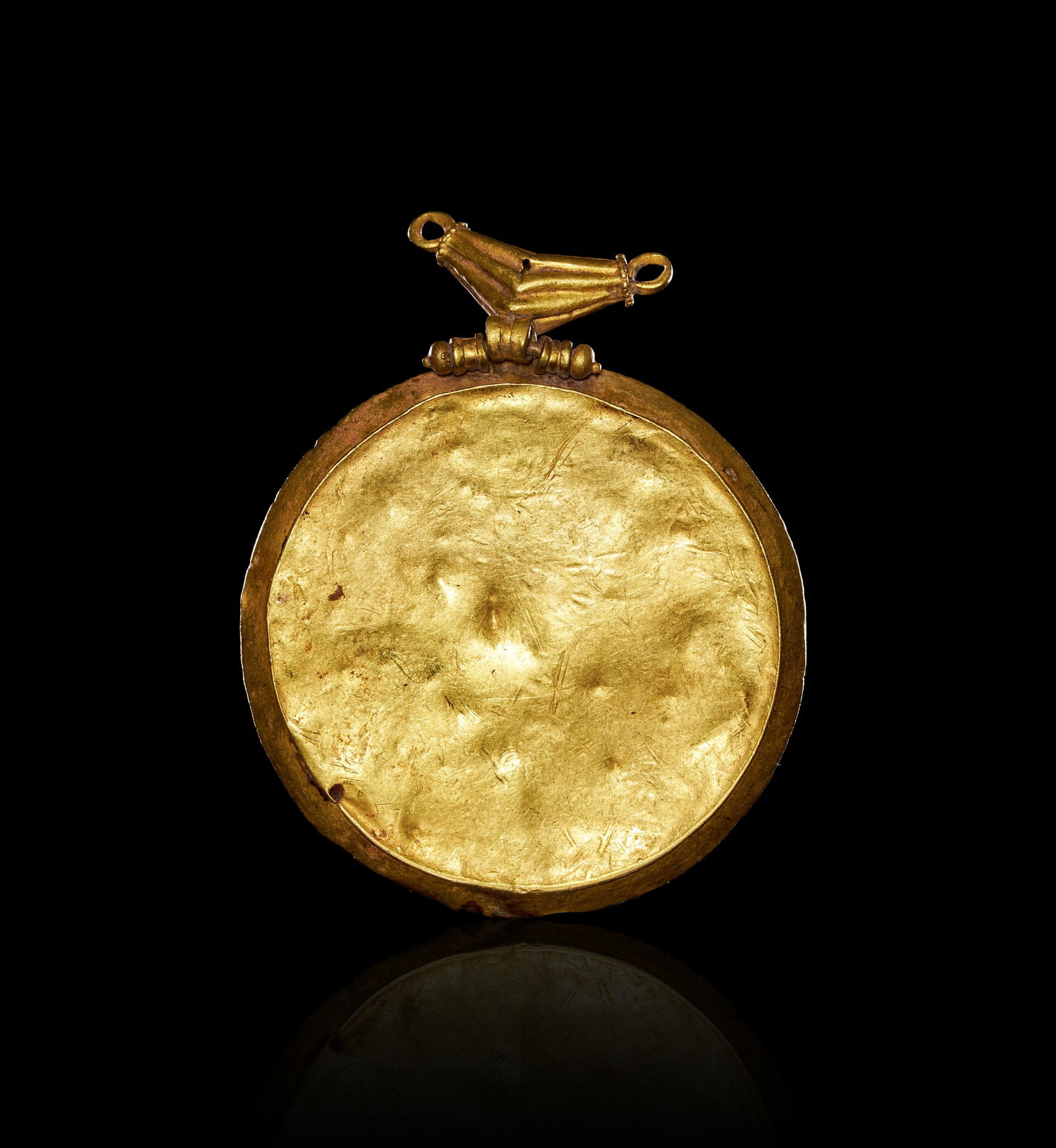 AN EARLY JEWISH GOLD MENORAH AMULET,LATE ROMAN TO BYZANTINE PERIOD, CIRCA 4TH-5TH CENTURY A.D.: AN EARLY JEWISH GOLD MENORAH AMULET, LATE ROMAN TO BYZANTINE PERIOD, CIRCA 4TH-5TH CENTURY A.D.Of circular form, the thin gold sheet worked in repoussé and bordered by a twisted rope-pattern frame. T
