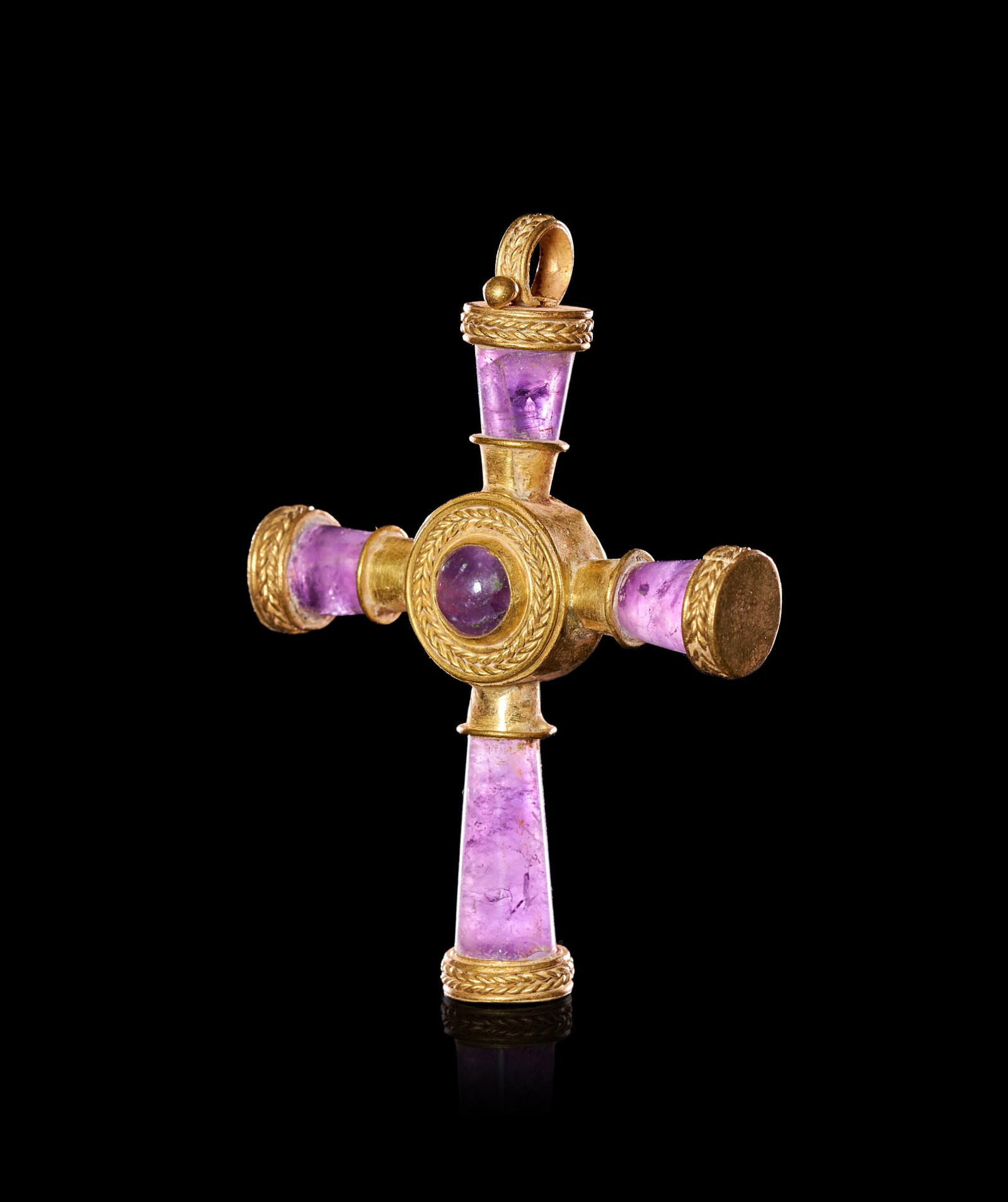 A BYZANTINE GOLD AND AMETHYST CROSS CIRCA 7TH-9TH CENTURY A.D.: A BYZANTINE GOLD AND AMETHYST CROSS PENDANT, EASTERN MEDITERRANEAN, CIRCA 7TH-9TH CENTURY A.D.Of Latin-cross form, composed of four tapering amethyst arms set into gold sleeves and converging on a cen