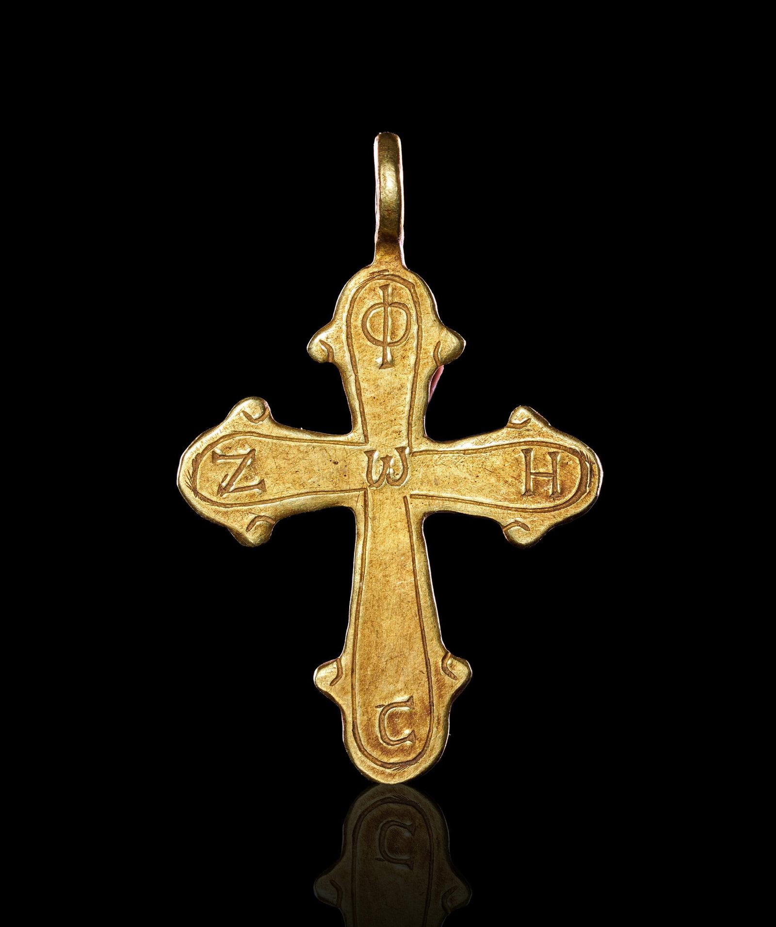 A GREEK BYZANTINE GOLD CROSS CIRCA 5TH-7TH CENTURY A.D.: A BYZANTINE GOLD INSCRIBED CROSS PENDANT, EASTERN MEDITERRANEAN, CIRCA 5TH-7TH CENTURY A.D. Of Latin form with flaring arms terminating in trefoil finials, the body cut from sheet gold and surmounted 