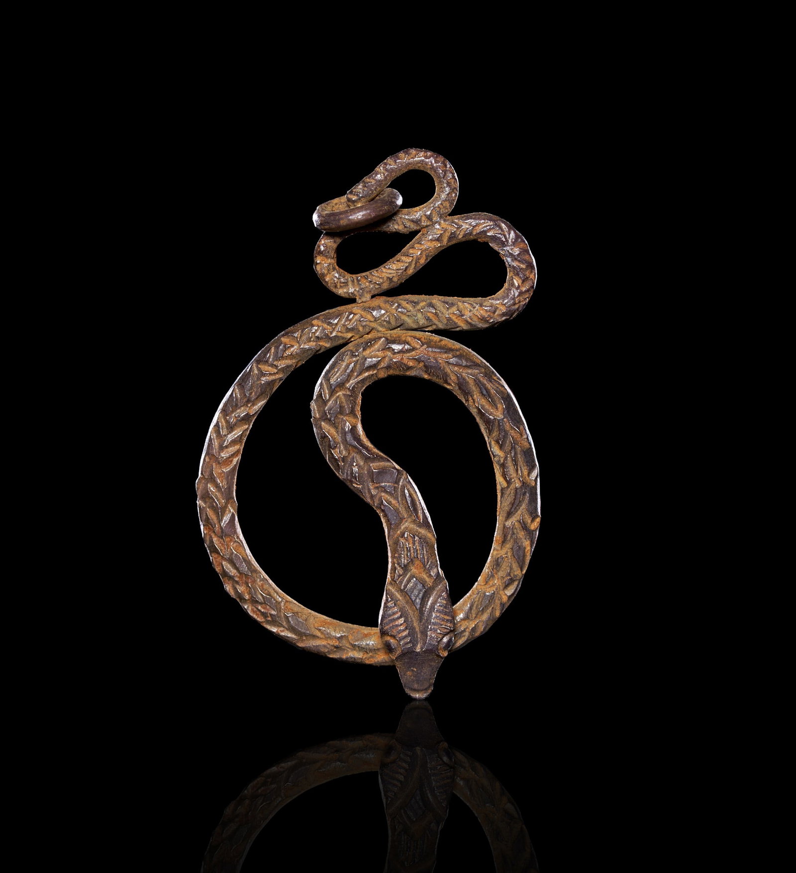A ROMAN SILVER SERPENT AMULET, CIRCA 1ST-2ND CENTURY A.D.: A ROMAN SILVER SERPENT AMULET, CIRCA 1ST-2ND CENTURY A.D. Worked from a flat sheet of silver into the form of a coiled serpent, the body rising from a downward-pointing triangular head, curving throug