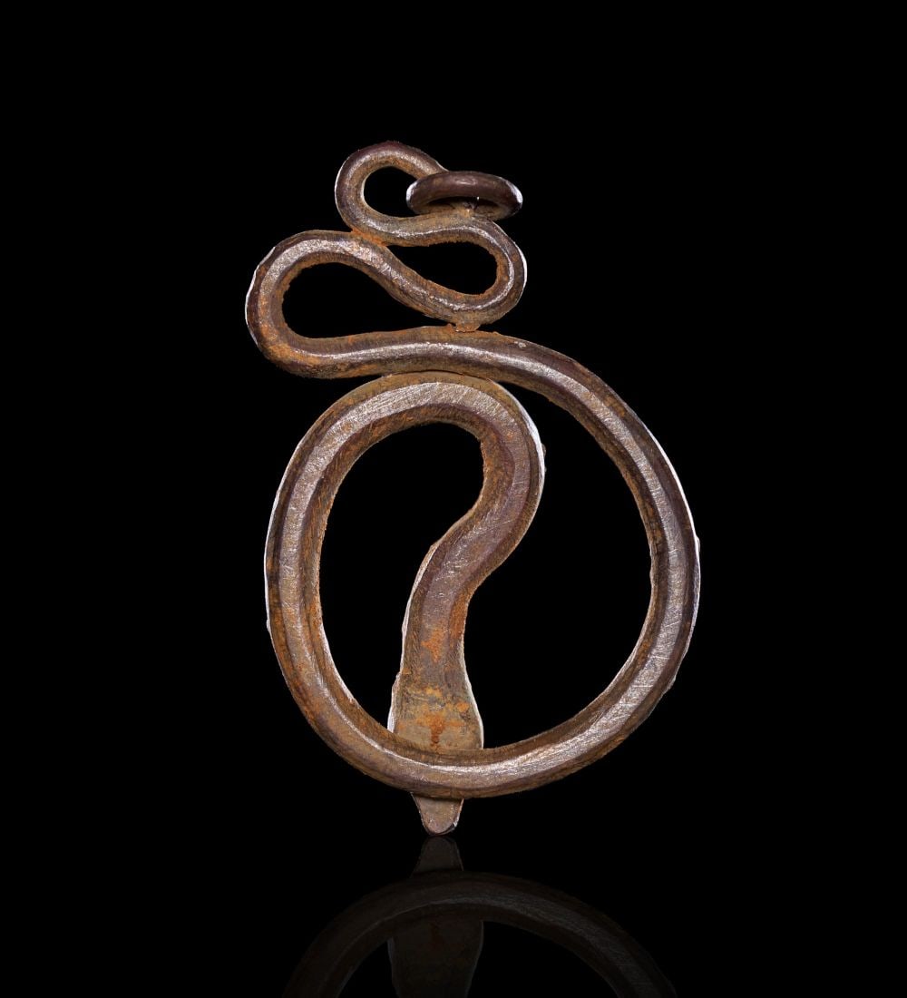 A ROMAN SILVER SERPENT AMULET, CIRCA 1ST-2ND CENTURY A.D.: A ROMAN SILVER SERPENT AMULET, CIRCA 1ST-2ND CENTURY A.D.Worked from a flat sheet of silver into the form of a coiled serpent, the body rising from a downward-pointing triangular head, curving through