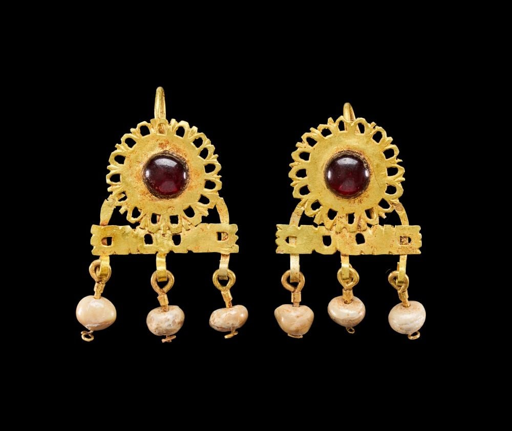 A PAIR OF EASTERN ROMAN GOLD AND GARNET EARRINGS CIRCA 2ND CENTURY A.D.: A PAIR OF EASTERN ROMAN GOLD, GARNET AND PEARL EARRINGS, CIRCA 2ND CENTURY A.D. Each earring of disc form surmounted by a suspension loop, the sheet-gold body pierced and cut around its circumference 