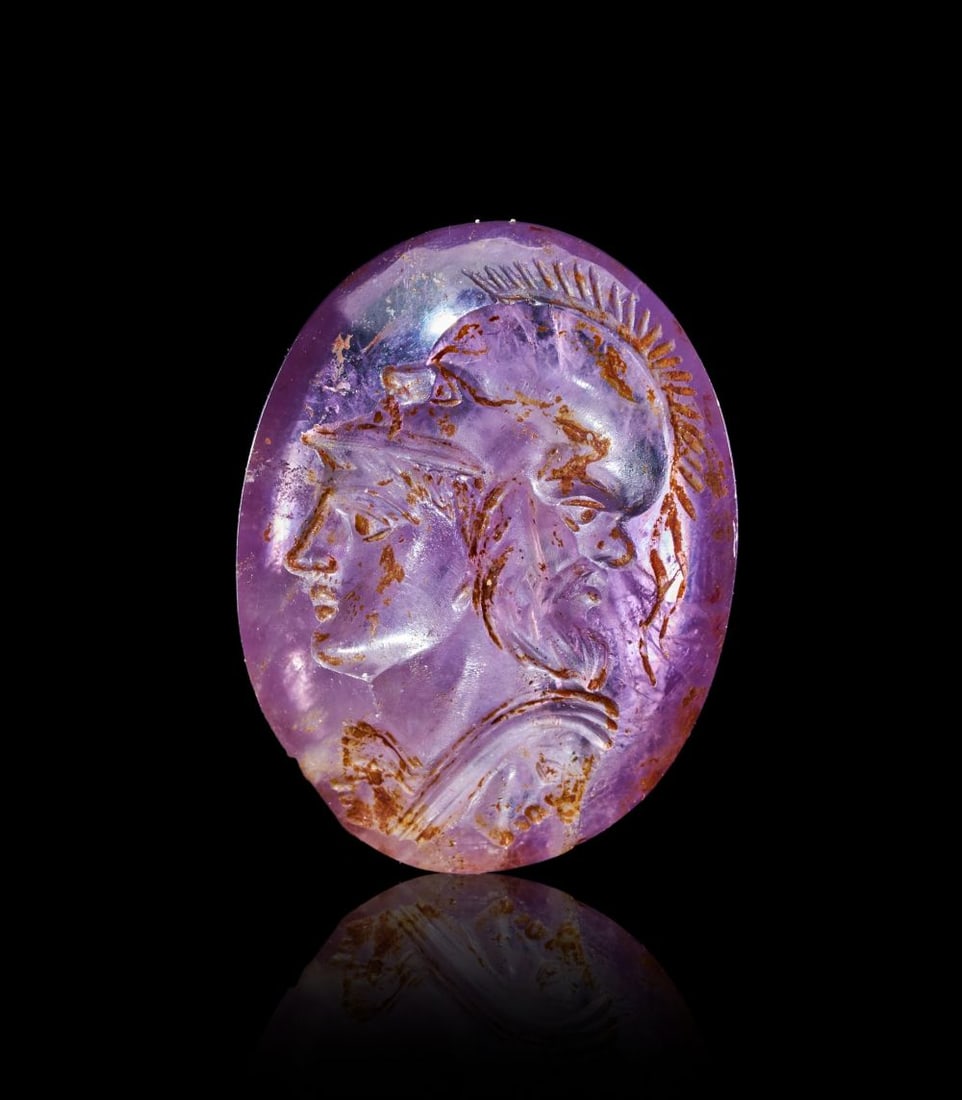 A ROMAN AMETHYST INTAGLIO OF A GRYLLOS WITH THE IMAGE OF FIVE FACES, CIRCA 1ST CENTURY A.D.: A ROMAN AMETHYST INTAGLIO OF A GRYLLOS WITH THE IMAGE OF FIVE FACES, CIRCA 1ST CENTURY A.D. Carved from translucent violet amethyst with fine internal veining and areas of natural iron-stained inclusi