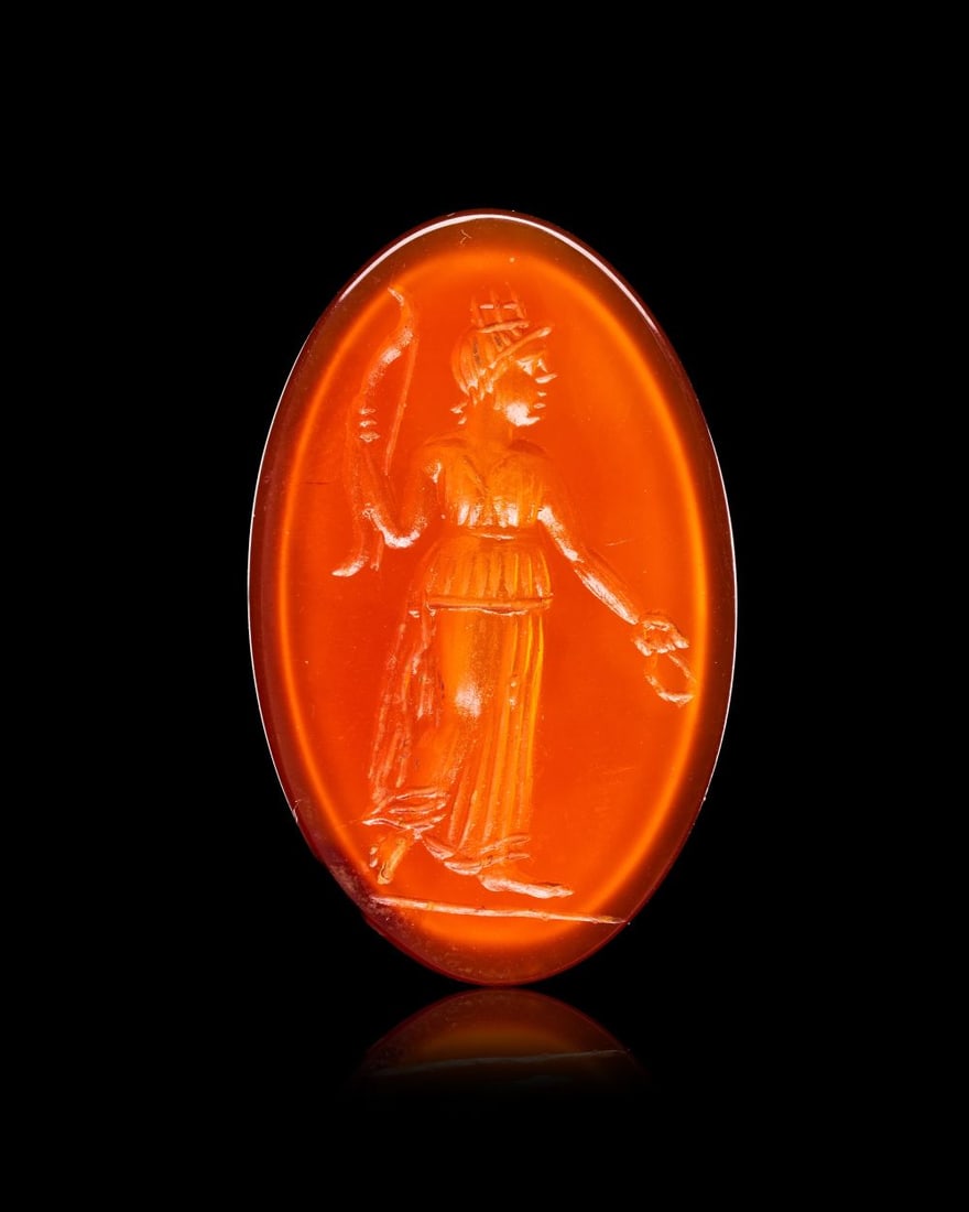 A ROMAN CARNELIAN INTAGLIO DEPICTING A ARCHER, CIRCA 2ND-3RD CENTURY A.D.: A ROMAN CARNELIAN INTAGLIO DEPICTING AN ARCHER, CIRCA 2ND-3RD CENTURY A.D. Of oval form with a flat engraved face and gently domed reverse, the translucent orange carnelian carved in intaglio with a s