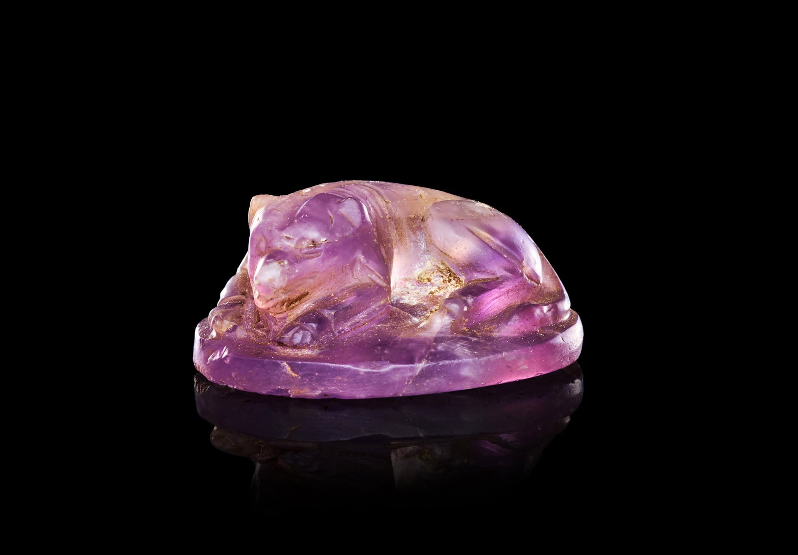 A ROMAN, AMETHYST SEAL DEPICTING A RECUMBENT HOUND, CIRCA 2ND-3RD CENTURY A.D.: A ROMAN AMETHYST SEAL DEPICTING A RECUMBENT HOUND, CIRCA 2ND-3RD CENTURY A.D.Of domed oval form, carved in the round from a translucent stone of pale violet tone, the upper surface worked into the fig
