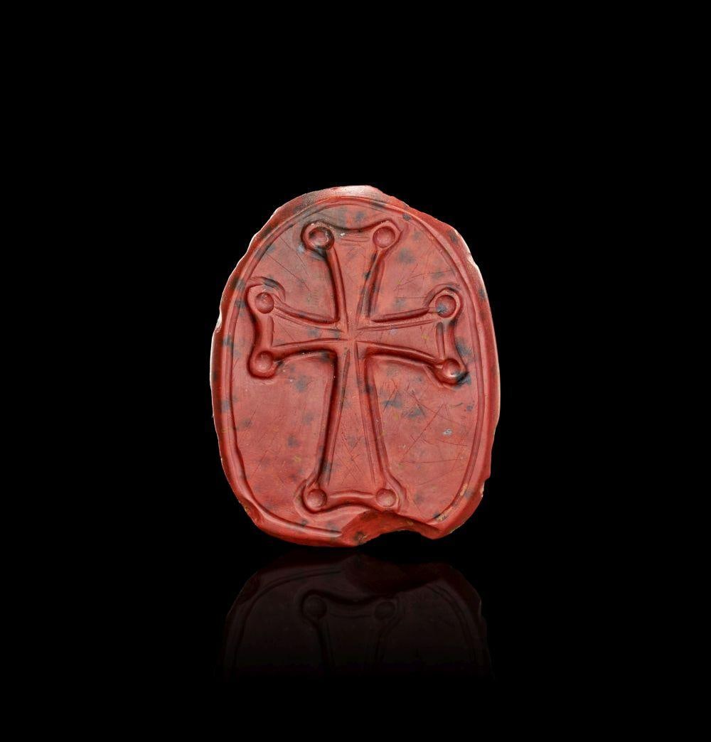 A CARVED JASPER CAMEO OF CHRIST PANTOKRATOR WITH CROSS REVERSE, 11TH-12TH CENTURY A.D.: A CARVED JASPER CAMEO OF CHRIST PANTOKRATOR WITH CROSS REVERSE, 11TH-12TH CENTURY A.D. Superbly executed oval cameo carved in richly mottled red and black jasper, presenting a striking frontal bust of