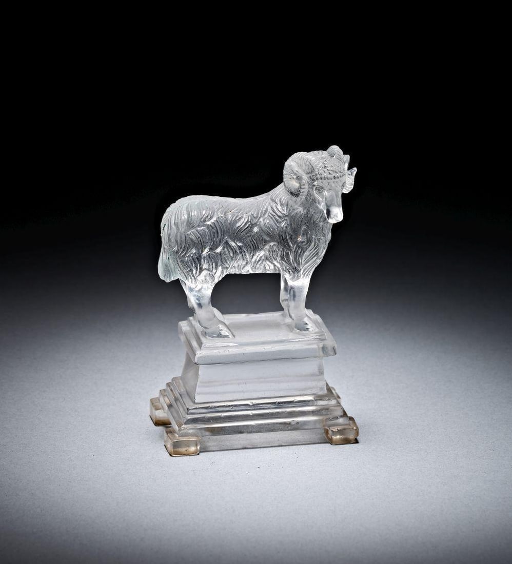 AN EXCEPTIONAL LATE GREEK ROCK CRYSTAL RAM ON PEDESTAL, CIRCA 3RD CENTURY A.D.: AN EXCEPTIONAL LATE GREEK ROCK CRYSTAL RAM ON PEDESTAL, CIRCA 3RD CENTURY A.D. Carved from clear rock crystal, this small figure of a ram stands on an integral stepped pedestal, the whole object cut w