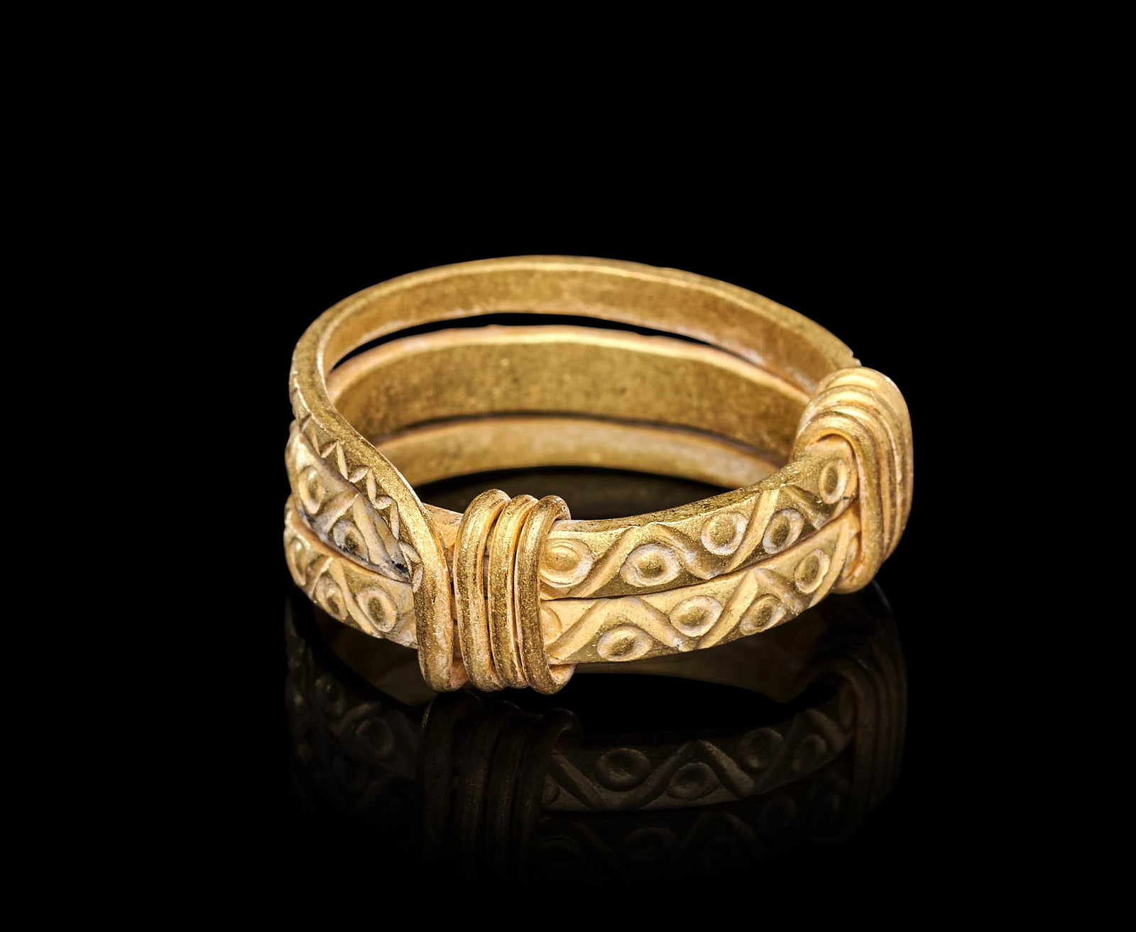 A VIKING GOLD RING, CIRCA 9TH-10TH CENTURY A.D.: A VIKING GOLD RING, CIRCA 9TH-10TH CENTURY A.D.Formed of a broad hoop composed of three parallel gold bands held together at the shoulders by transverse gold wire wrappings, the outward-facing surface