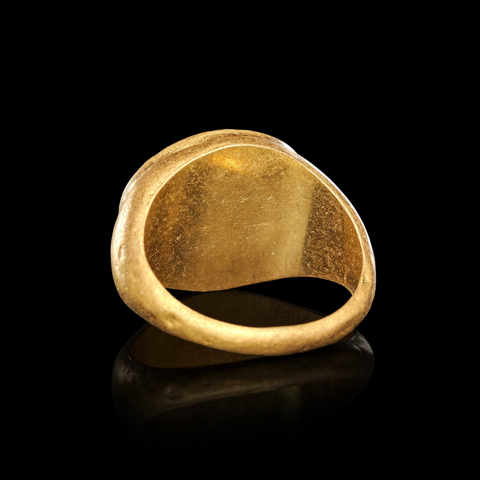 A ROMAN JASPER INTAGLIO DEPICTING A JANUS ON A GOLD SETTING, CIRCA 1ST-2ND CENTURY A.D.: A ROMAN JASPER INTAGLIO DEPICTING A JANUS ON A GOLD SETTING, CIRCA 1ST-2ND CENTURY A.D. The oval intaglio of deep red jasper is set within a plain gold bezel above a smooth, tapering hoop of circular 