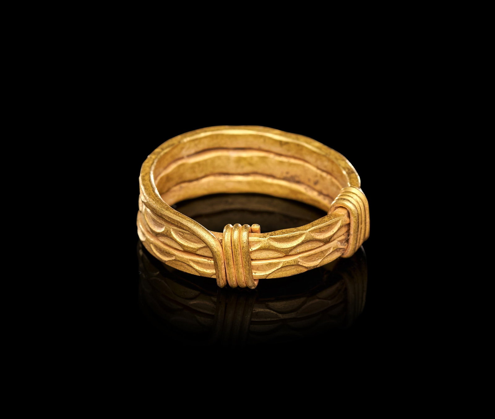 A VIKING GOLD RING, CIRCA 9TH-10TH CENTURY A.D.: A VIKING GOLD RING, CIRCA 9TH-10TH CENTURY A.D.Formed from three parallel gold rods of lentoid section, bound together at the shoulders by tightly coiled gold wire wrapping that secures the hoop and p