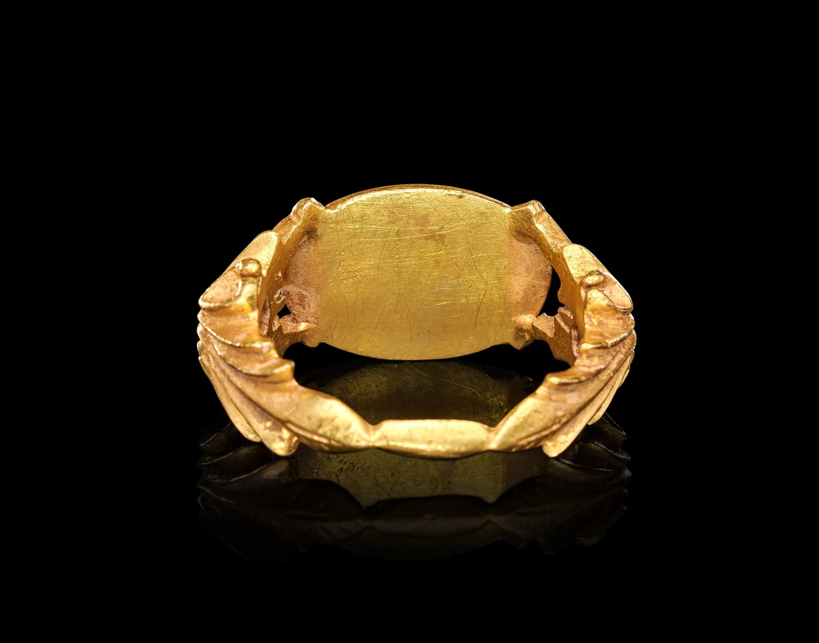 A ROMAN GOLD "LOVERS" RING CIRCA 1ST CENTURY B.C.-1ST CENTURY A.D.: A ROMAN GOLD "MARRIAGE" RING, CIRCA 1ST CENTURY B.C.-1ST CENTURY A.D.Of substantial construction in high-karat gold, the ring formed as a broad oval bezel flanked by openwork shoulders worked into scr