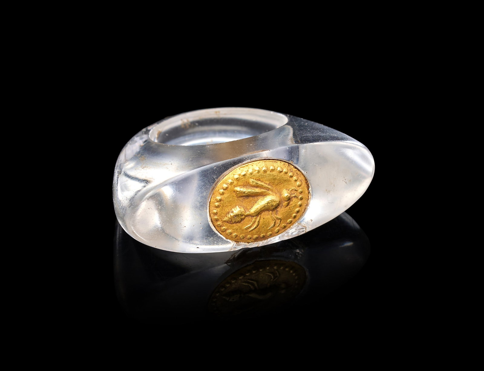 A RARE EGYPTIAN ROCK CRYSTAL & GOLD RING DEPICTING A WASP, NEW KINGDOM, DYNASTY XVIII, AMARNA PERIOD: A RARE EGYPTIAN ROCK CRYSTAL AND GOLD RING DEPICTING A WASP, NEW KINGDOM, DYNASTY XVIII, AMARNA PERIODOf elongated oval form, the hoop cut from a single piece of transparent rock crystal into a slende